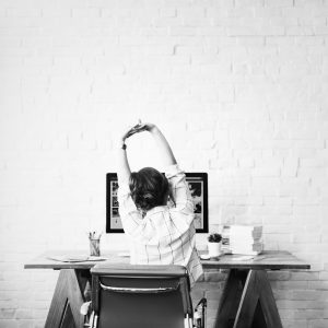 una donna che si stiracchia alla scrivania